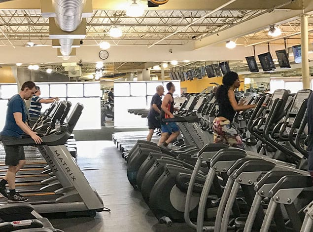 gym members doin cardio training with cardio machines.